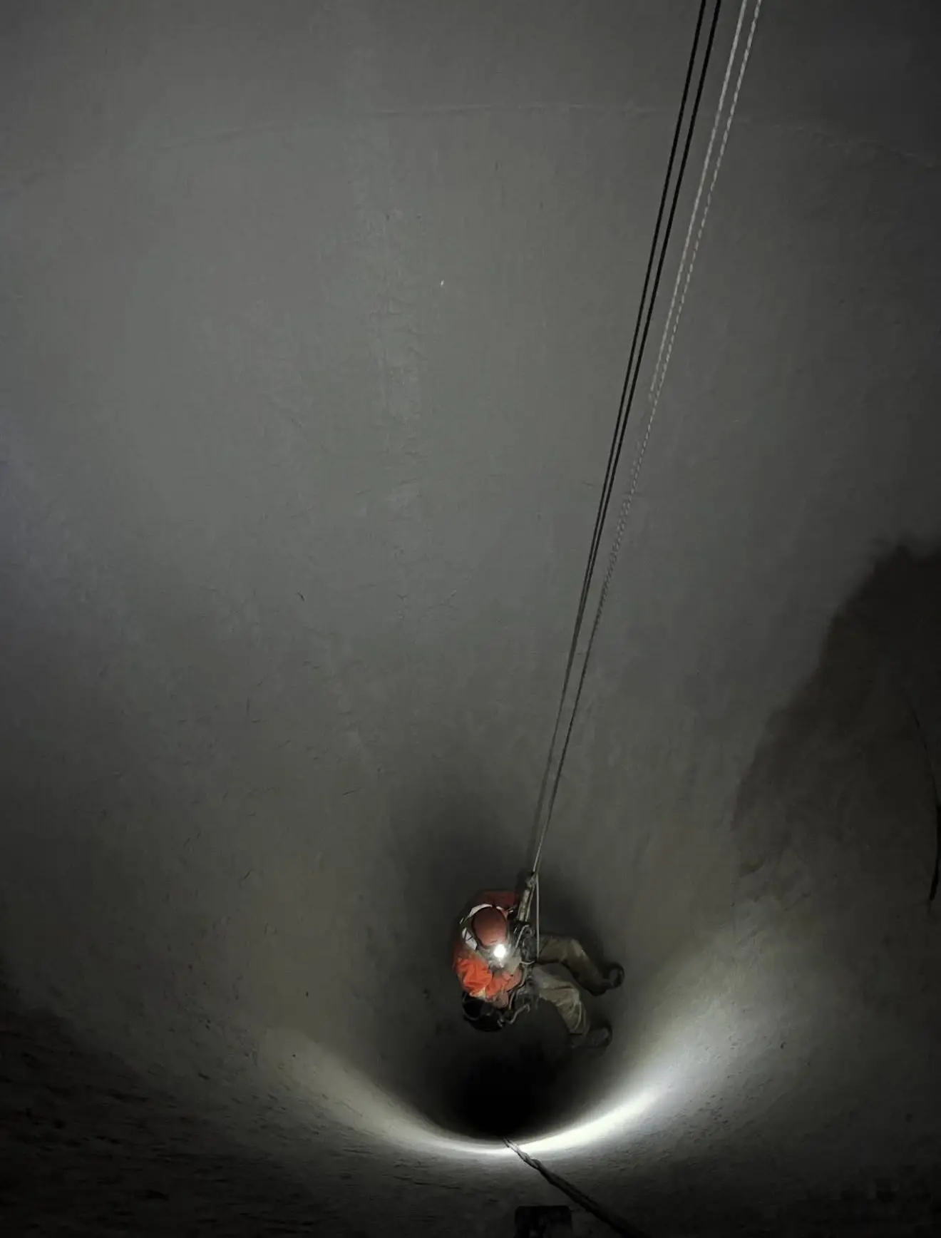 Rope technician descending inside a large confined space