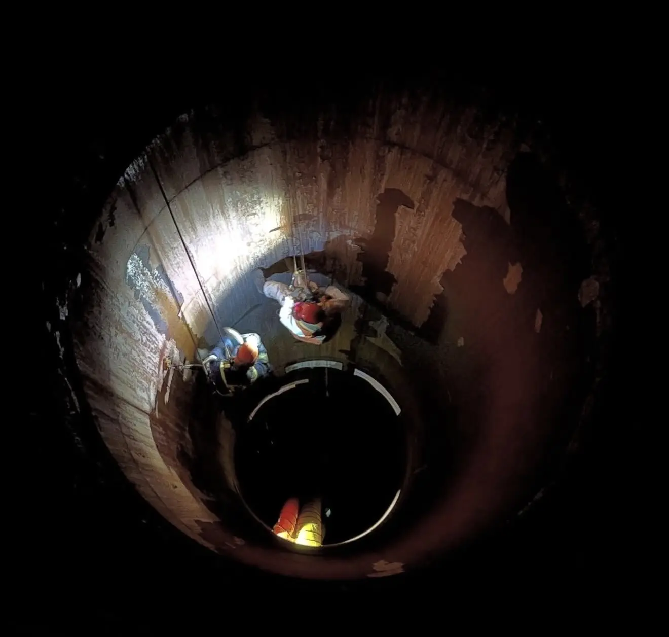 Technicians performing work inside an industrial shaft